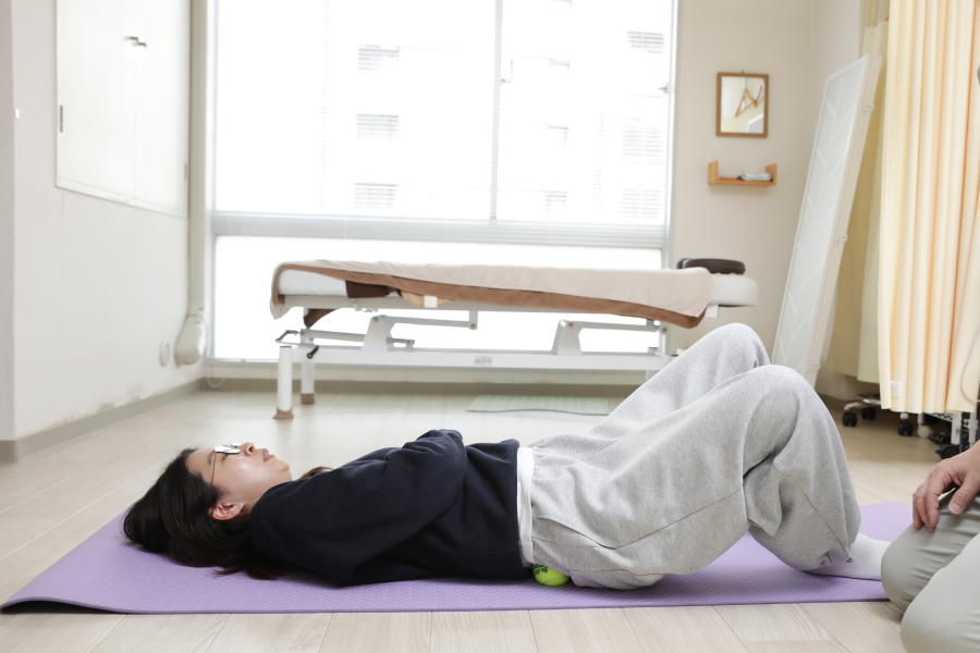 2.ゆっくりとテニスボールに体重をかけていき、痛気持ちいいくらいのところでストップします。