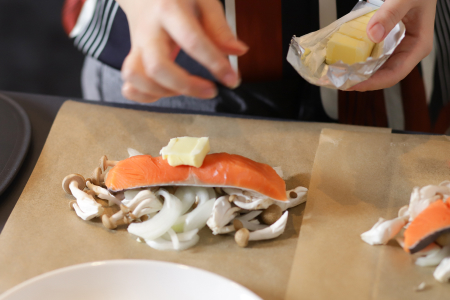 クッキングシートの上に、玉ねぎ→きのこ→鮭→バターの順にのせる。