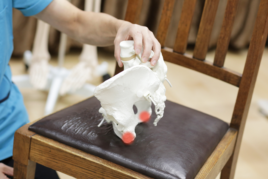 まずは、デスクの椅子に座る際、お尻の下にある二点の硬い骨（坐骨）を探し、その二点で均等に体重を支え、骨盤を立てることを意識してみてください。