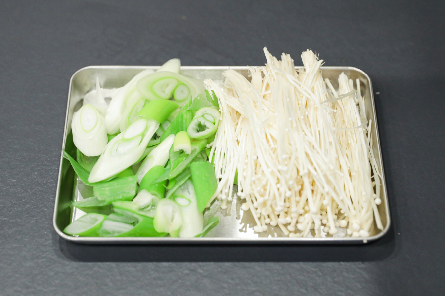 2.えのきは石づきを取ってほぐし、長ねぎは斜め薄切りにする。